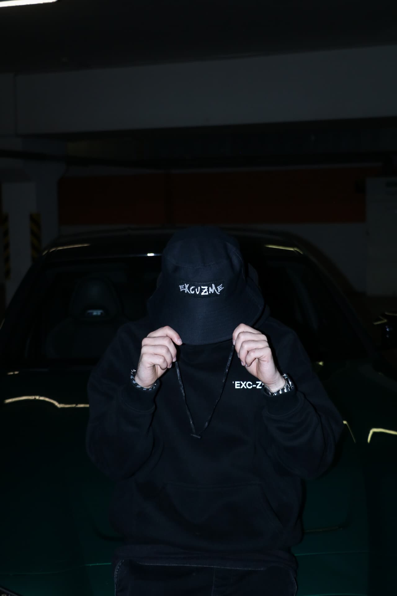 Excuzme bucket hat styled with a black hoodie.